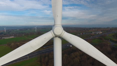 wind-turbine-front-blades-drone-aerial-inspection-and-back-tracking-with-highway